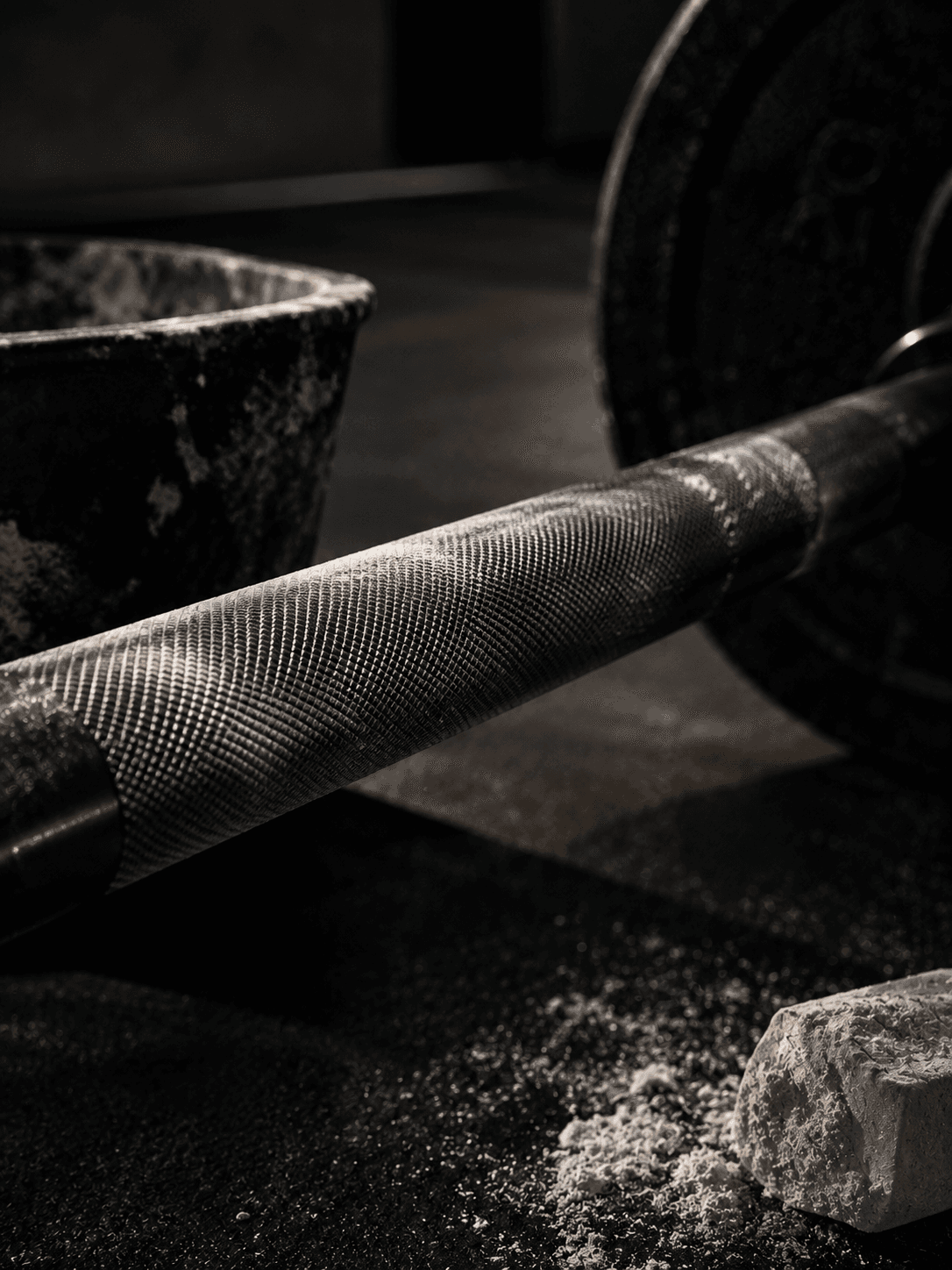 close crop of a loaded barbell knurling with chalk residue