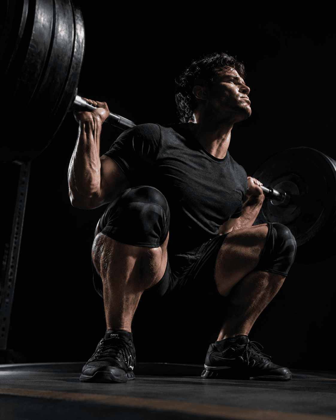 a lifter at the bottom of a heavy squat on the platform deck, shot from a low angle